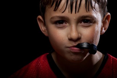 Sweaty boy with mouthguard in his mouth provided from Sparkle Dental in Dorchester, MA